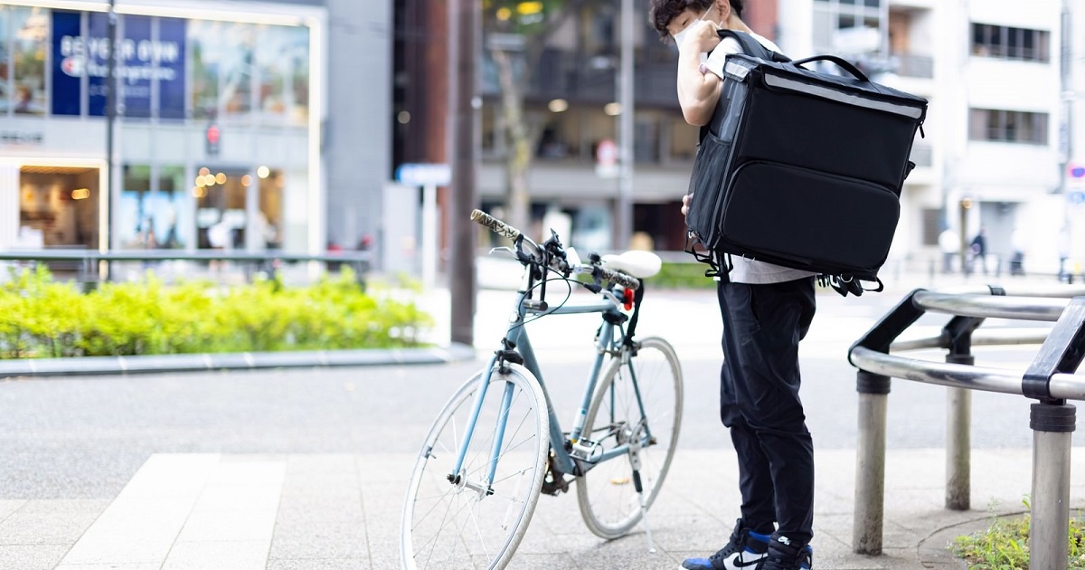 ウバッグを背負う男性配達員_1200_630