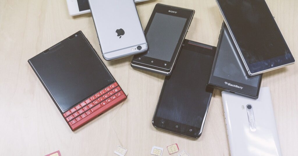 複数台の検証機(スマホ)と散らばるSIMカード_1200_630