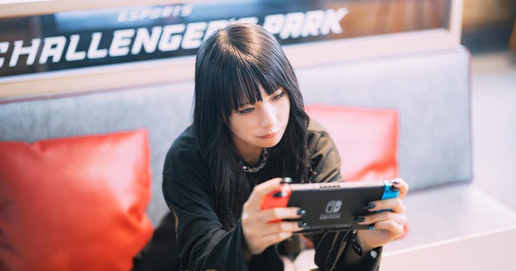 eスポーツ施設で携帯ゲームをプレイする女性_1200_630