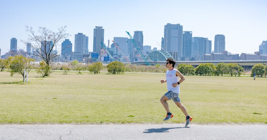 淀川河川公園西中島地区の河川敷でランニングする男性_1200_630